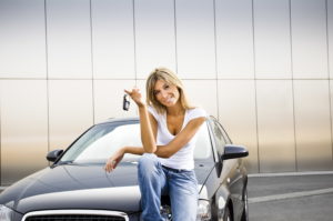 Young woman holding keys to new car